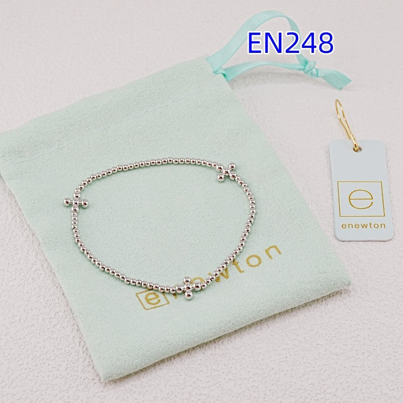 White-gold elastic beaded bracelet with small cross charm, stretchy metal bead chain