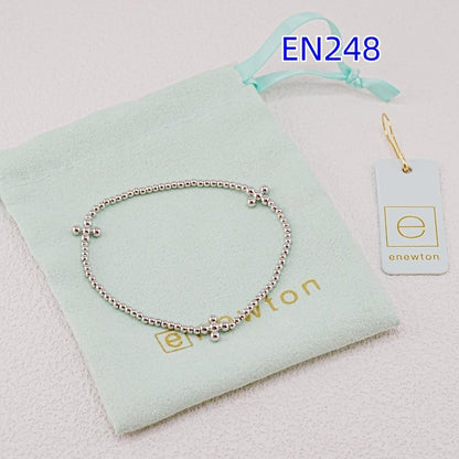 White-gold elastic beaded bracelet with small cross charm, stretchy metal bead chain