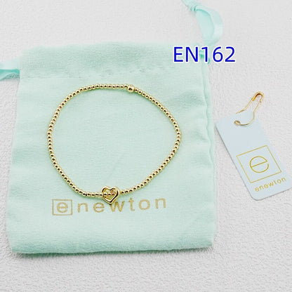 Gold heart-pendant beaded bracelet with small heart charm centerpiece