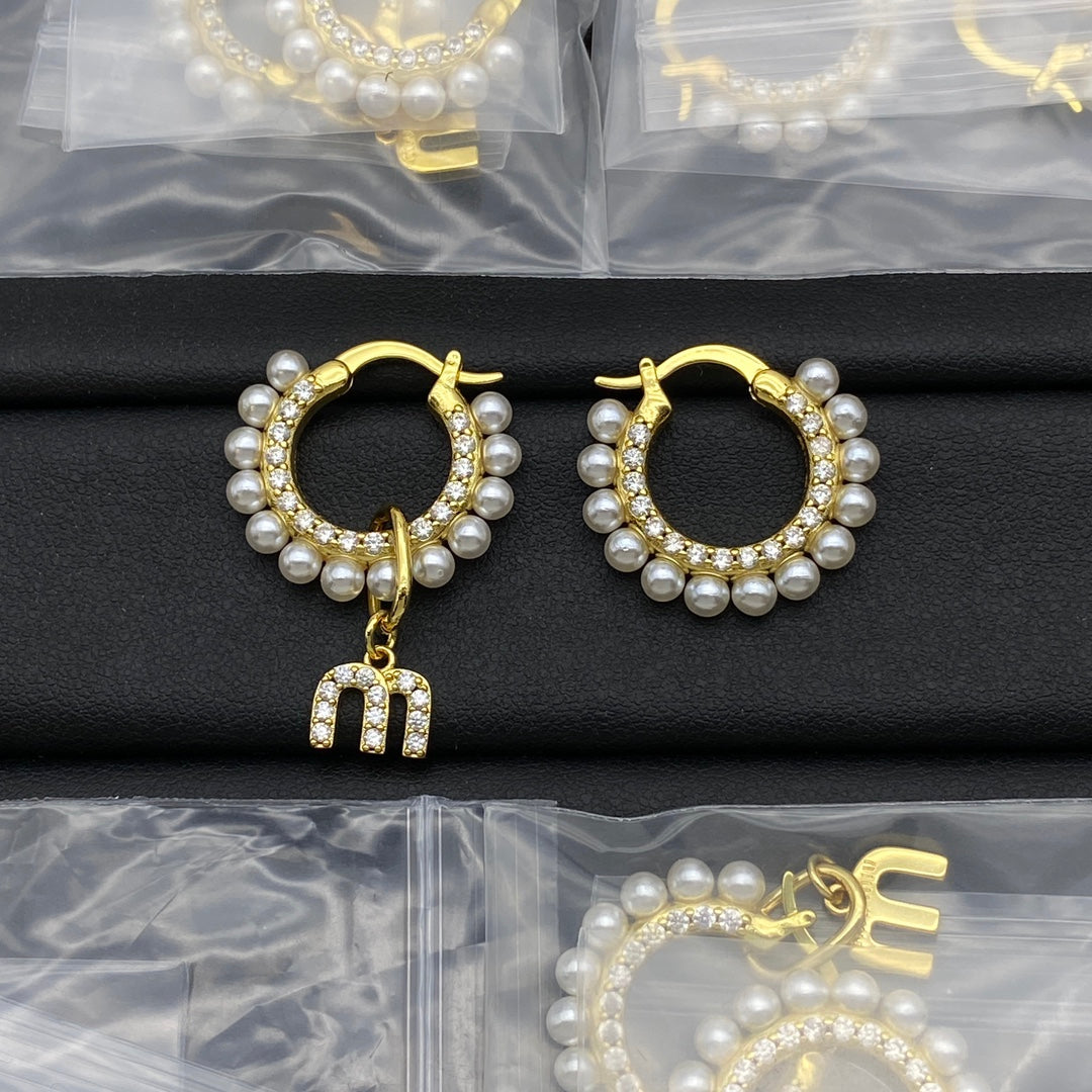Gold pearl and crystal hoop earrings with dangling letter charm