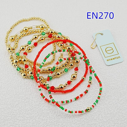 Assorted beaded bracelets with gold-tone balls and red-and-green bead strands, flat lay