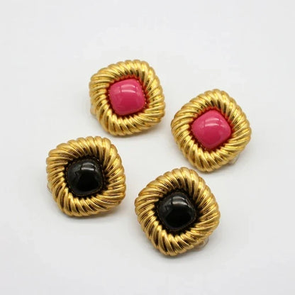 Gold-tone scalloped stud earrings with pink and black cabochon centers, set of two