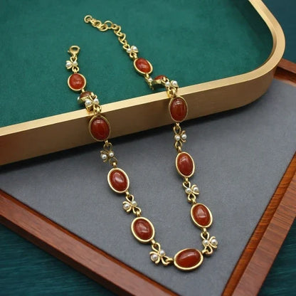 Vintage red oval glass necklace with matching dangling earrings and gold bow links