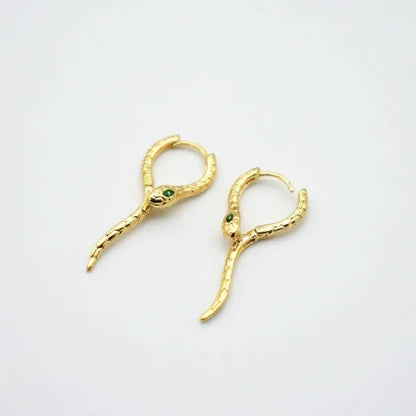 Gold-tone snake hoop ear cuffs with green crystal eyes and hinged clasp hooks