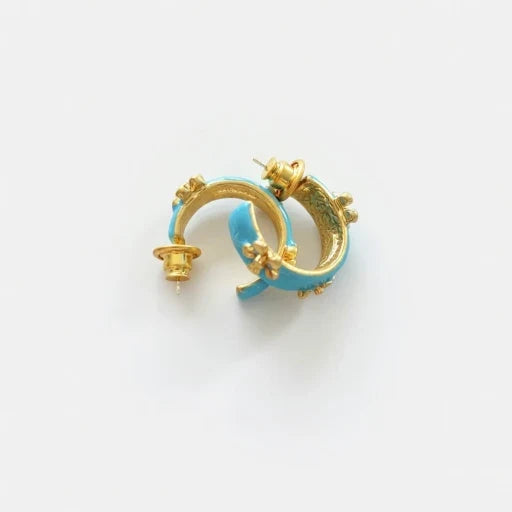 Blue enamel C-shaped hoop earrings with gold-tone embossed flower accents