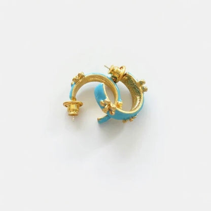 Blue enamel C-shaped hoop earrings with gold-tone embossed flower accents