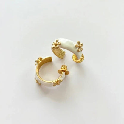 Cream enamel C-shaped hoop earrings with gold-tone raised flower details
