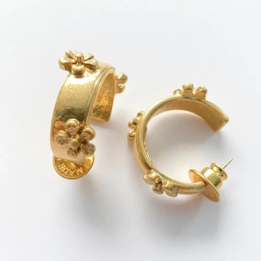 Antique gold-tone C-shaped hoop earrings with raised floral cluster details