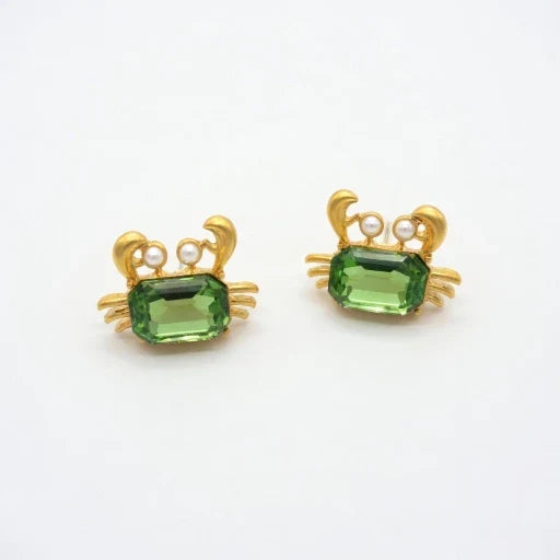 Crab-shaped crystal stud earrings with gold-tone settings, pearls, and a green gem