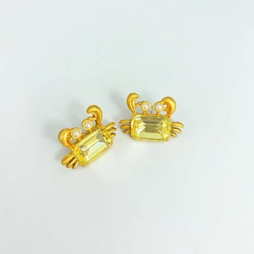 Crab-shaped crystal stud earrings with gold-tone settings, pearls, and a yellow-gold gem