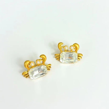 Crab-shaped crystal stud earrings with gold-tone settings, pearls, and a clear gem